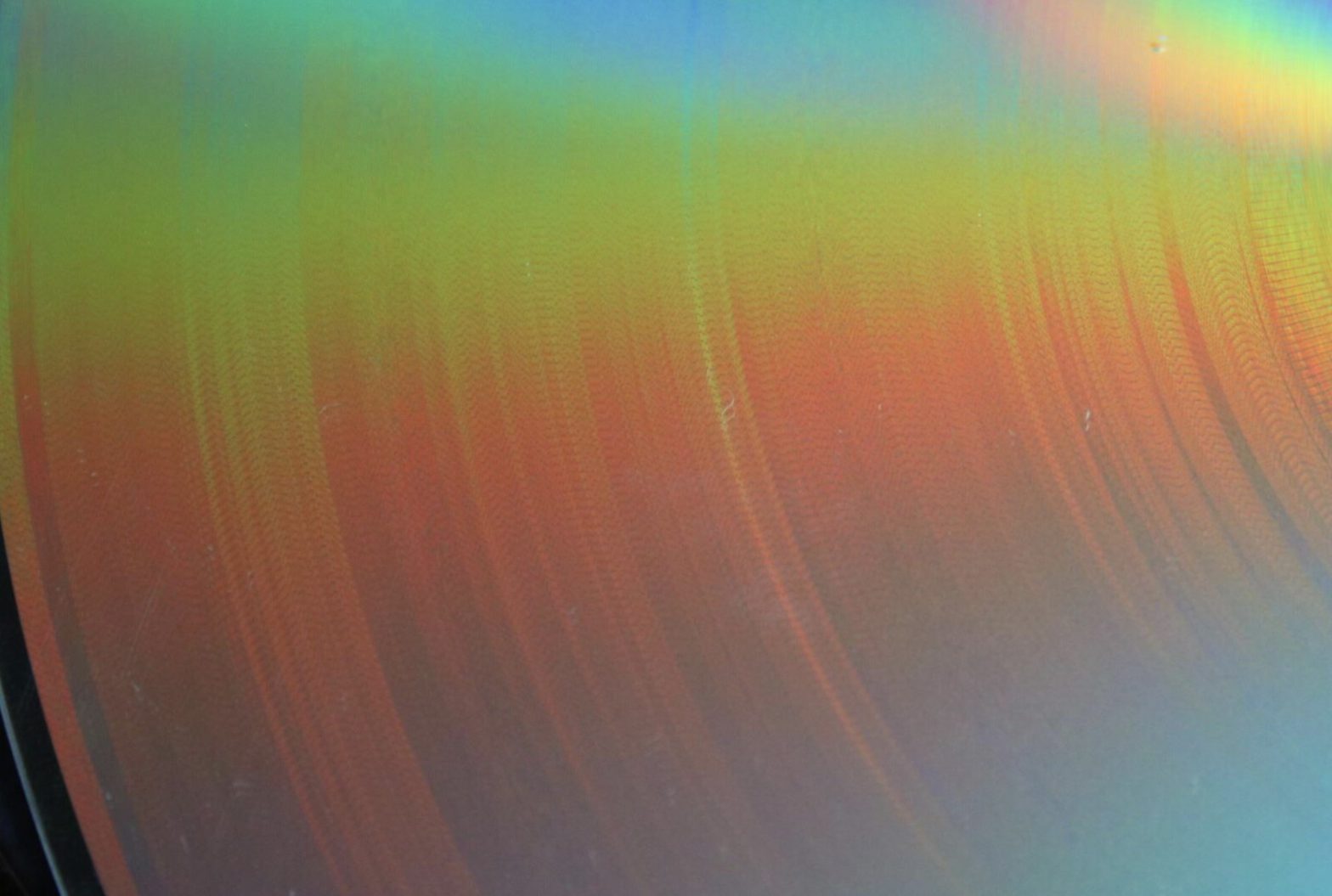 A shiny surface with a rainbow coloured refraction playing across it